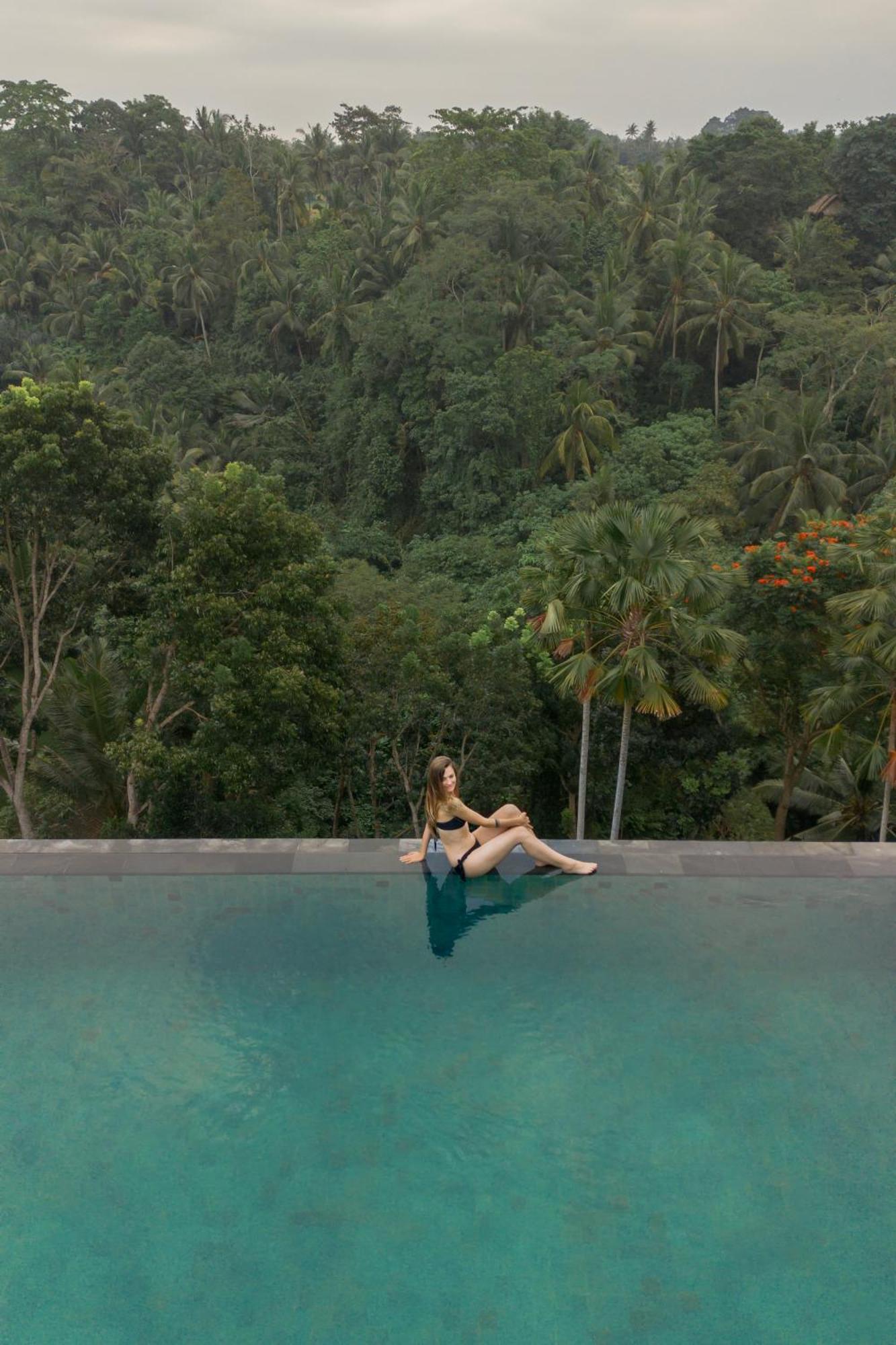 Goya Boutique Resort Убуд Экстерьер фото A woman sitting on the edge of a swimming pool